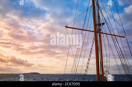 Old sailing ship mast at beautiful sunrise, travel concept. Stock Photo