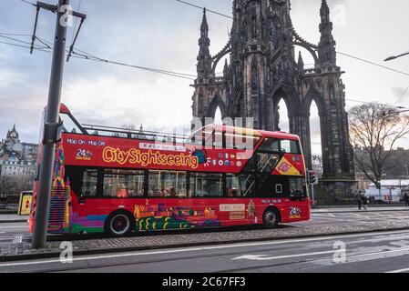 CitySightseeing Hop-On Hop-Off bus in front of Scott Monumen to Scottish author Sir Walter Scott in Edinburgh, the capital of Scotland, part of UK Stock Photo