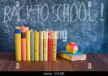 Back to school after the coronavirus lockdown, education supplies, books,  message on blackboard Stock Photo