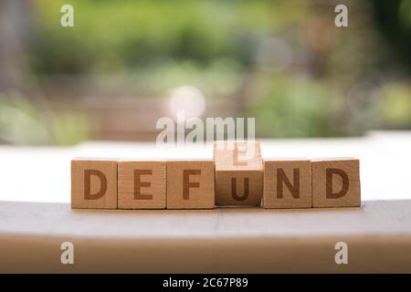 DEFEND DEFUND Police concept on wood blocks as finger changes Stock Photo