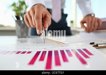 Finances holding a pen and pointing to a document Stock Photo