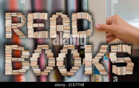 Read books letters with young student picking a book from the shelf in the library in the background. Stock Photo