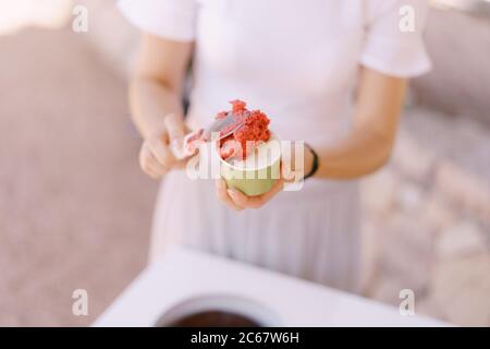 Ice cream seller puts the ice cream in the cup. Stock Photo