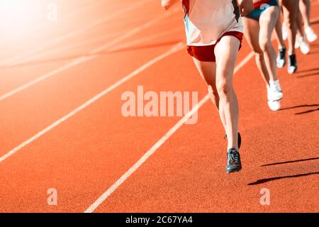 Athletics people running on the track field. Sunny day. Vintage color filter Stock Photo
