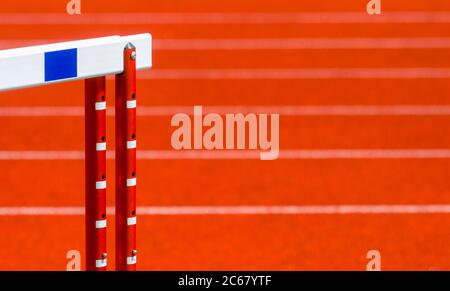 Hurdle on the red running track prepared for competition. Individual sport concept Stock Photo