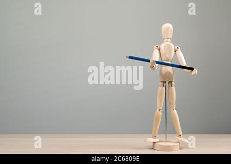 Wooden figure mannequin holding blue pencil Stock Photo