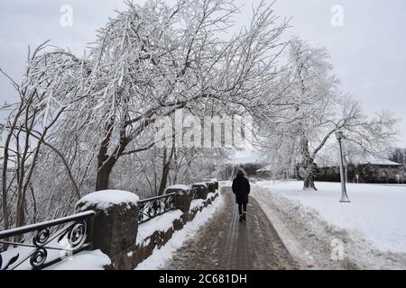 The riverside path in Queen Victoria Park during wintertime at Niagara Falls on the Canadian side. A man is enjoying the walk and view in a warm coat. Stock Photo