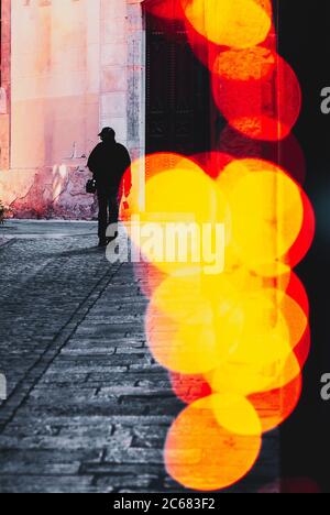 Silhouette of one man walking the city street in high contrast black ...