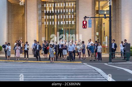 Pedestrian waiting to cross the road at Kitte Shopping complex, Tokyo, Japan Stock Photo