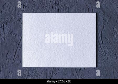 white textured paper card on dark gray solid background Stock Photo