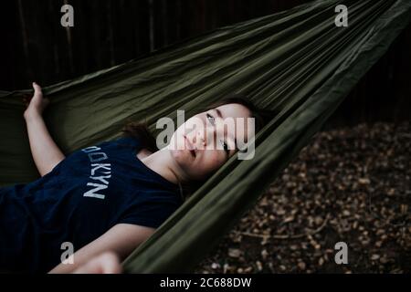 Preteen girl laying in hammock outside Stock Photo