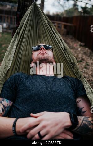 Vertical of man relaxing in hammock outside Stock Photo