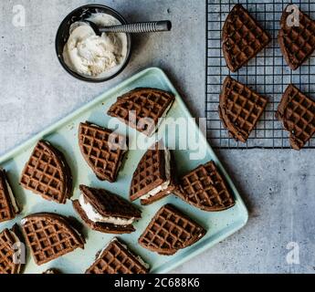 Homemade ice cream sandwiches and ingredients on green sheet pan. Stock Photo