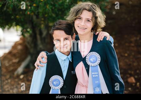 Brother and sister smile for the camera with their recital ribbons Stock Photo