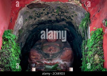 Leshan, China - July 2019 : Small Buddha figure shrine in a smal cave cut on the wall of a Rocky Mountain on the way to the The  Giant Leshan Buddha, Stock Photo