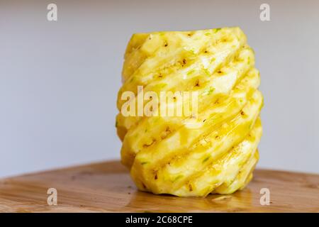 Close up of whole peeled pineapple on a wooden cutting board Stock Photo