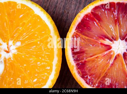 Two slices of blood orange and orange on a wooden background Stock Photo