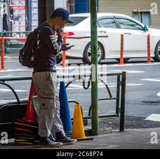 Man smoking in a designated smoking area, Nakameguro, Tokyo, Japan Stock Photo