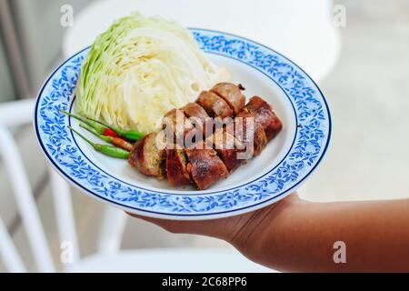 Sai Au (Nothern Thai Spicy Sausage) served on plate with chinese cabbage and chilli Stock Photo