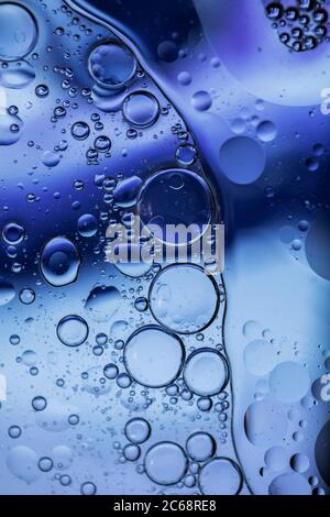 Oil bubbles in water. Blue and purple colors. Stock Photo