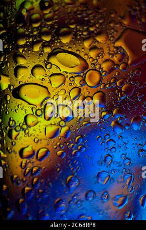 Oil bubbles in water. blue, yellow and purple colors. Stock Photo