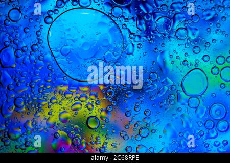 Oil bubbles in water. Blue and yellow  and black colors. Stock Photo