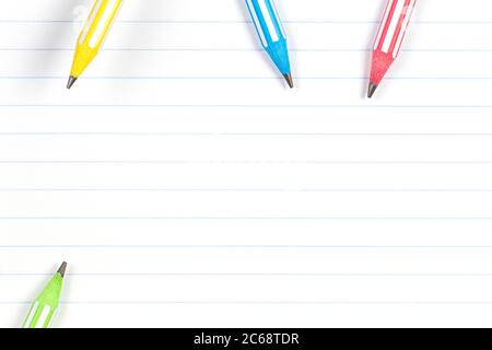 Colorful pencils on notebook lined paper background with copy space. Back to school, education, learning concept Stock Photo