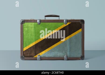 Tanzania flag on old vintage leather suitcase with national concept. Retro brown luggage with copy space text. Stock Photo