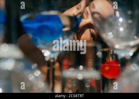 The girl with close eyes is through the glasses. The concept of psychological trauma. Schizophrenia, bipolar disorder, alcoholism, mental problems. Stock Photo