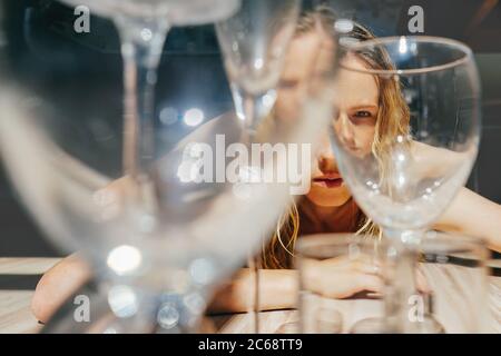 The girl looks through the glasses. The concept of psychological trauma. Schizophrenia, bipolar disorder, alcoholism, mental problems. Stock Photo