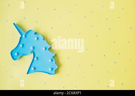 Blue unicorn with blue stars on yellow backdrop. Festive concept. Flat lay style. Stock Photo