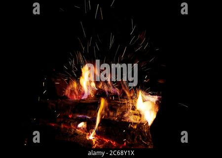 Sparks from firewood burning in a fireplace. Winter heating at home. Heat and energy in fire Stock Photo