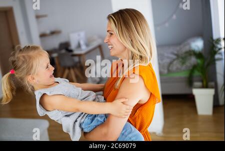 Happy loving family. Mother and her daughter child girl playing and hugging. Stock Photo