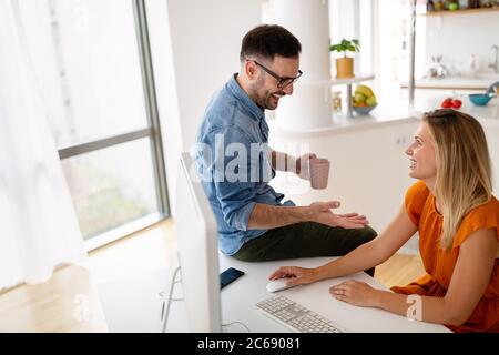 Taking time to chat with colleague. Happy business people discussing something and smiling Stock Photo