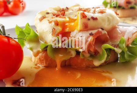 Eggs Benedict on toasted muffins with ham and sauce Stock Photo
