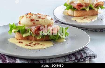 Eggs Benedict on toasted muffins with ham and sauce Stock Photo