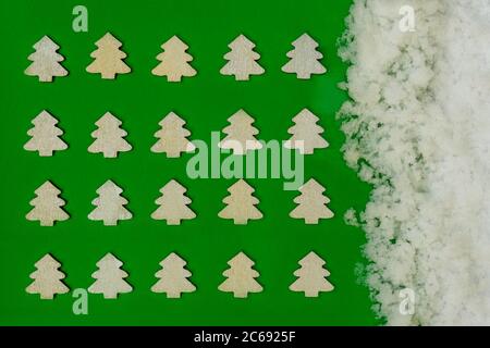 Creative layout made of Christmas silver trees on green background and snow background right. Flat lay. Minimalism. Stock Photo