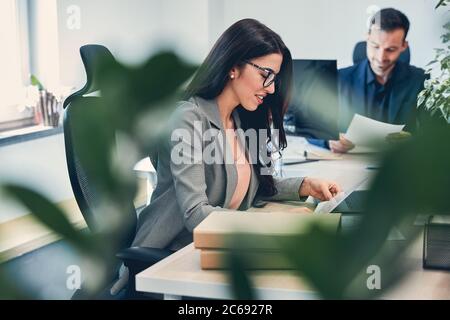 Young pretty Caucasian businesswoman is taking note Stock Photo