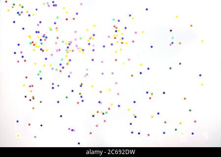 Multi-colored stars on a white background. Festive background of colorful confetti stars on a white background. Stock Photo