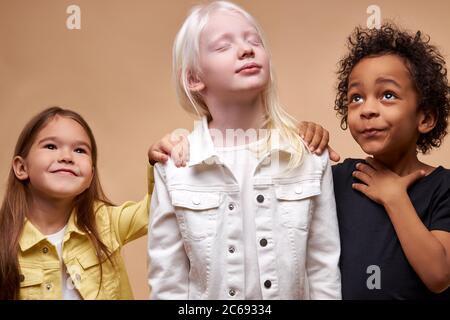 adorable kids of diverse nationalities and skin colors stand together ...