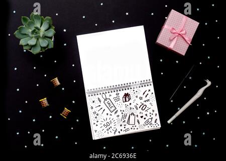 Sell-out flat lay with note, succulent, pen and gift box on black background with sparkles. Space for your text in notebook and Doodle in note. Stock Photo