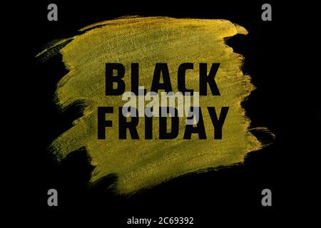 Black friday. Black lettering on gold acrylic paint strokes. Stock Photo