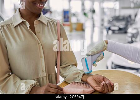 dealership staff checking temperature of clients before looking at cars, while coronavirus, covid-19 all over the world Stock Photo