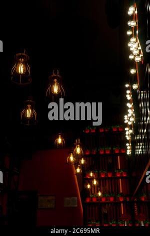 Minimalistic lamps decorated cafe in a modern loft style. Yellow color light. Blurred background as hallway. Stock Photo