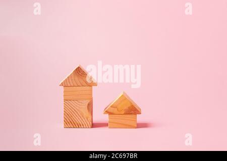 Children's wooden toys on a pink background concept zero west. Small houses the designer from developing color cubes Stock Photo