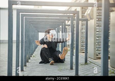 Handsome young man using VR headset outdoors Stock Photo