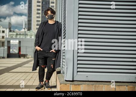 Stylish guy in medical face mask standing on the street Stock Photo
