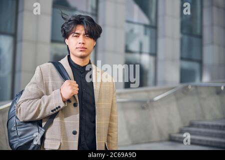 Good-looking young man standing on the street Stock Photo