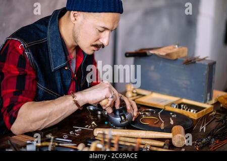 hardworking man making decorative items for people. close up side view photo Stock Photo