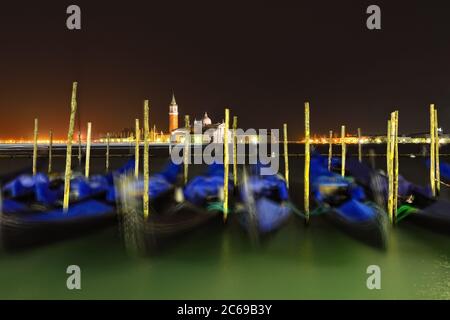 Gondolas moored by the square San Marco in Venice with the island San Giorgio Maggiore across the canal in the background at the night Stock Photo